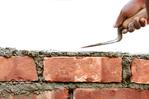 Bricklayer Laying Bricks on white background