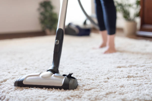 istock Woman using a vacuum cleaner while cleaning carpet in the house. 816907006