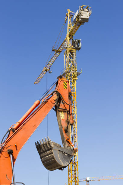 istock Orange excavator and crane against the blue sky 816941508