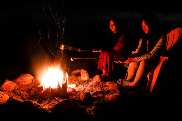 istock Two young women roast marshmallows on the beach 816953976