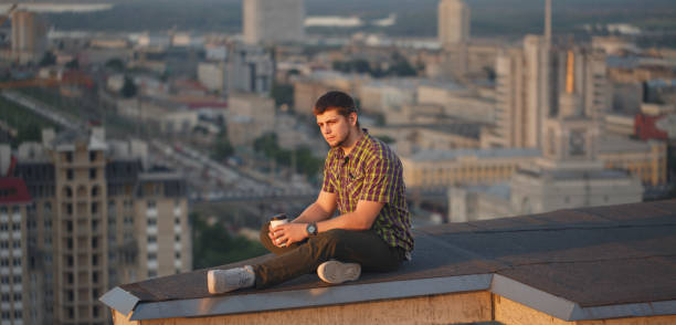 istock Man is drinking coffee on roof in morning 816968316