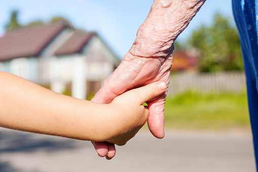 grandmother taking hand of young child, concept