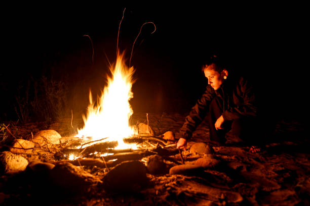 istock Young woman tends campfire 816978252