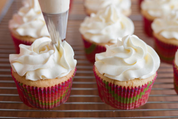 istock Baker decorates muffins with cream and confectionery nozzles 816978680