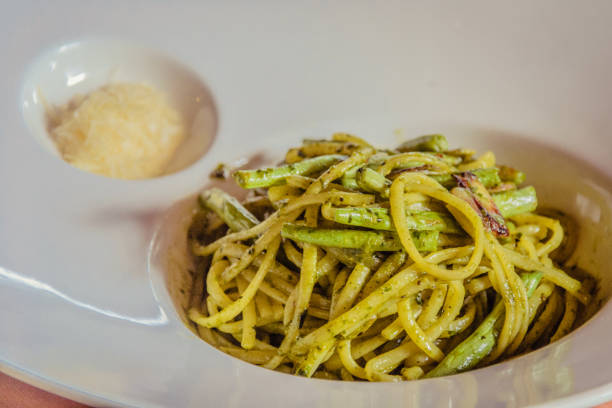 Linguine al pesto served with green beans and grated parmesan