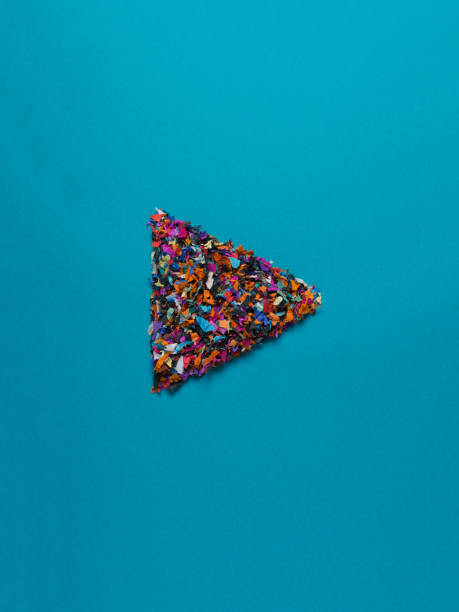 confetti play button play button made out of colorful confetti on a blue background play button photos stock pictures, royalty-free photos & images