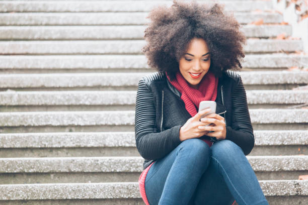 istock Attractive woman text meassaging on street 817026440