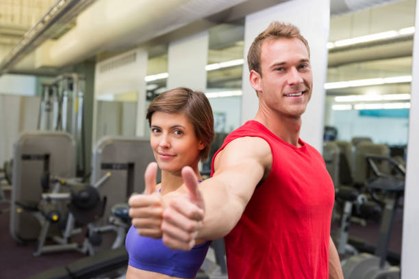 istock Fit attractive couple smiling at camera showing thumbs up 817036670