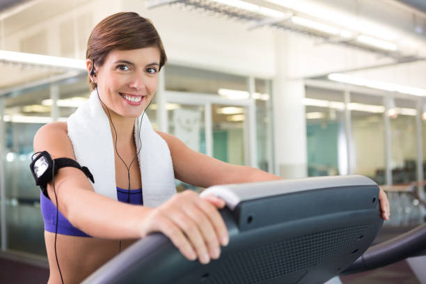 istock Fit brunette running on the treadmill listening to music 817037708