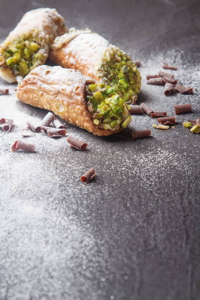 Sweet homemade cannoli stuffed with ricotta cheese cream and pis