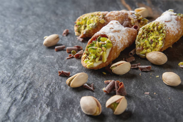 Sweet homemade cannoli stuffed with ricotta cheese cream and pis Sweet homemade cannoli stuffed with ricotta cheese cream and pistachial Sicilian dessert. Italian pastry. cannoli photos stock pictures, royalty-free photos & images