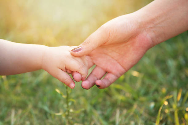 mani di mamma e bambino - holding hands human hand child mother foto e immagini stock