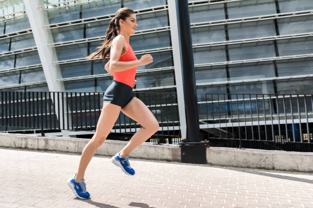 istock Joyful young woman running near stadium 817071336