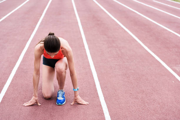 istock Concentrated female runner standing at starting position 817071730