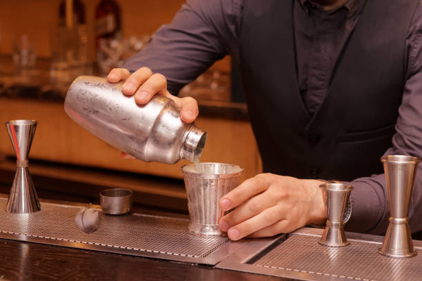 istock Bartender is pouring cocktail into a glass 817081364