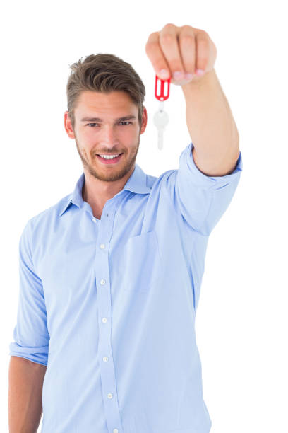 istock Handsome young man showing new house key 817084246