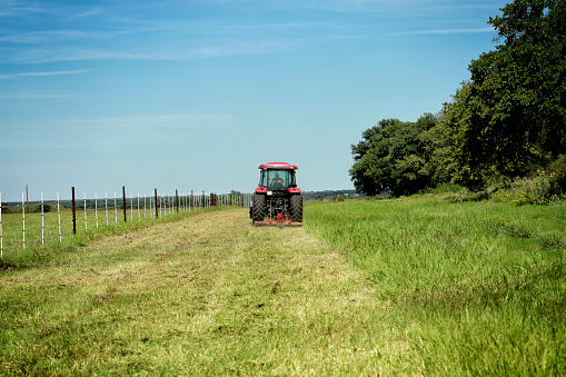 Farming: Large red tractor moving green farmers pasture