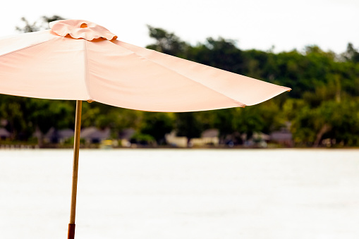 Pink beach umbrella, Vanuatu, background with copy space, full frame horizontal composition