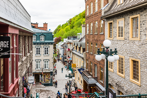 Quebec City: Lower old town streets called Rue du Petit Champlain and Sous Fort with people tourists walking by restaurants