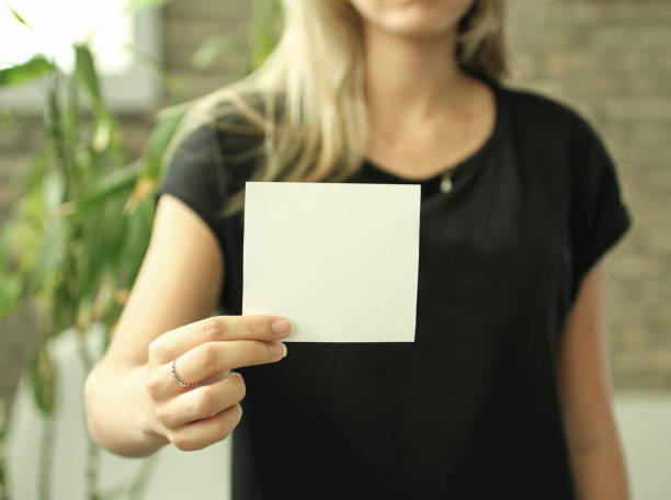 woman holding a white empty paper. - epmty imagens e fotografias de stock