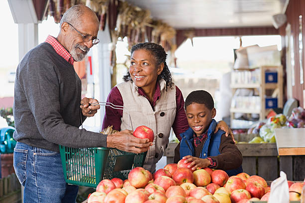 nonni e loro nipote scelta di mele - outdoors market foto e immagini stock