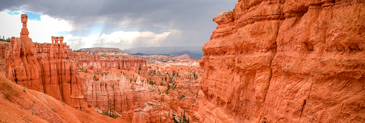 a panoramic of Thor's Hammer overlooking a rainstorm in Bryce Canyon National Park