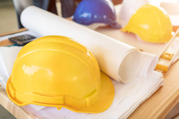 istock Engineer yellow helmet, calculator, level and project drawings on office table. Safety engineer concept. 817126168