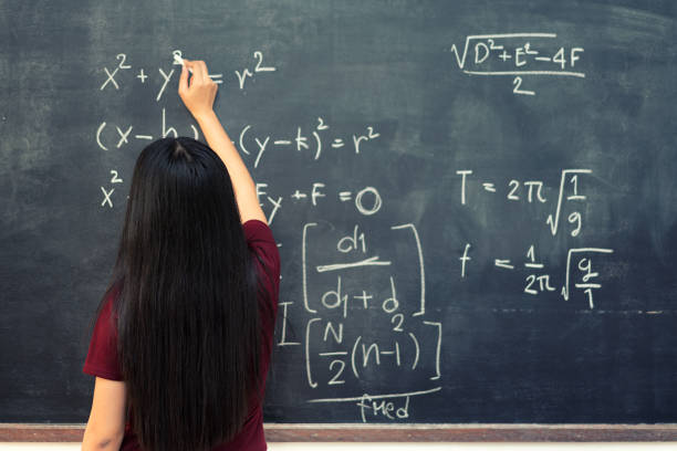 istock Beautiful Asian student writing on blackboard with chalk in classroom. 817128512