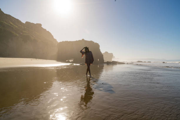 istock Serene Woman Walks the Ocean Seashore 817130890