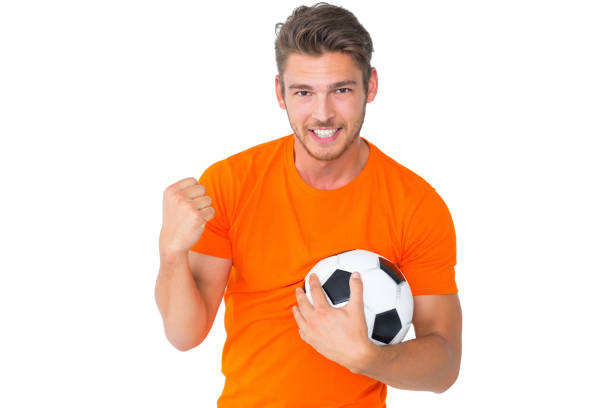 istock Excited man in orange cheering holding football 817131002