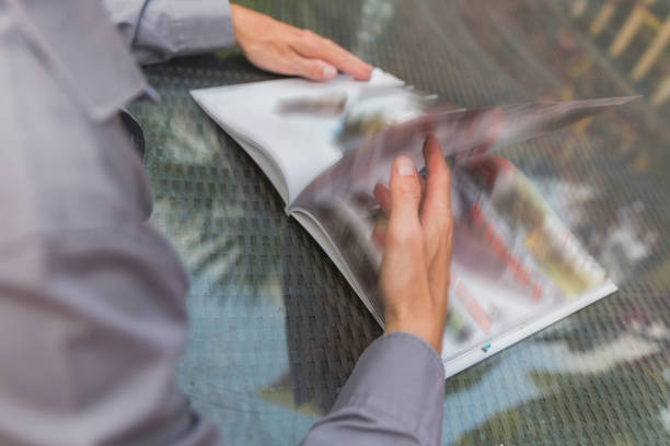 istock Males hands flipping magazine page 817131386