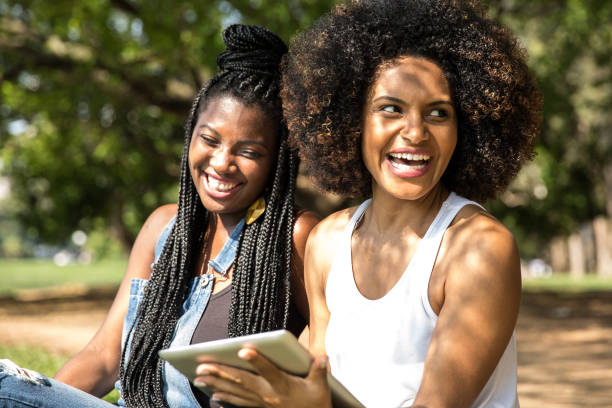 istock Afro friends using digital tablet in the park 817138614