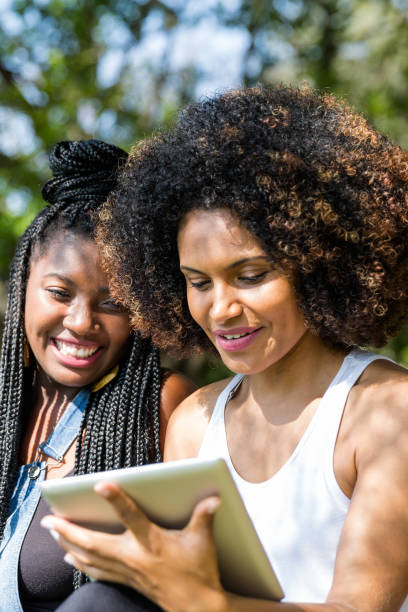 istock Afro friends using digital tablet in the park 817138648