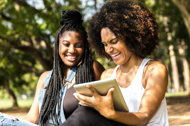 istock Afro friends using digital tablet in the park 817143474