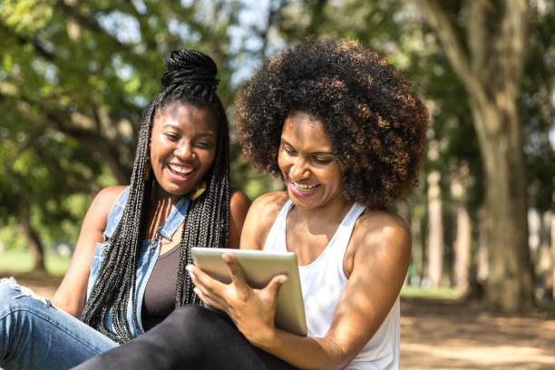istock Afro friends using digital tablet in the park 817143480