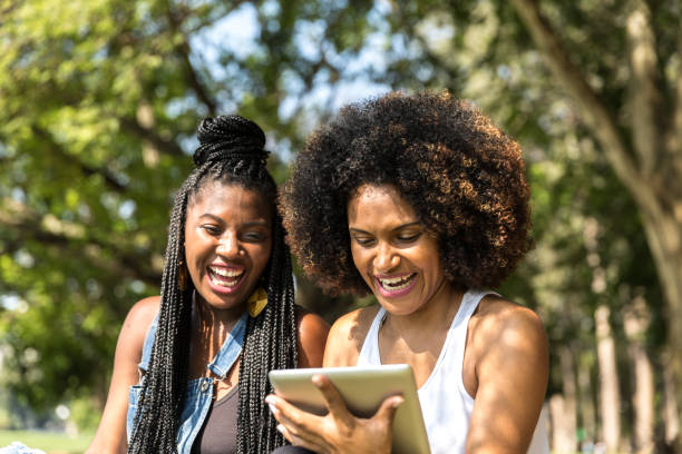 istock Afro friends using digital tablet in the park 817143482