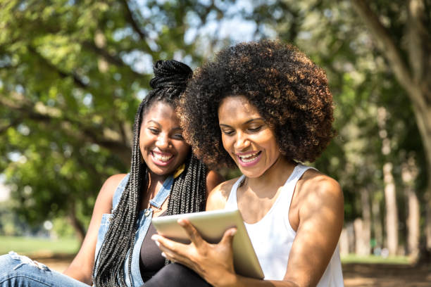 istock Afro friends using digital tablet in the park 817143490