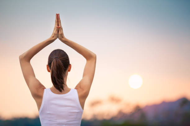 istock Woman meditating on the beach 817147632