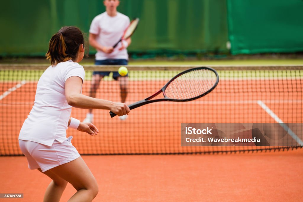 Tennis players playing a match on the court Tennis players playing a match on the court on a sunny day Tennis Stock Photo