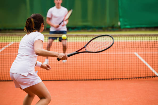 Tennis players playing a match on the court Tennis players playing a match on the court on a sunny day racket sport stock pictures, royalty-free photos & images