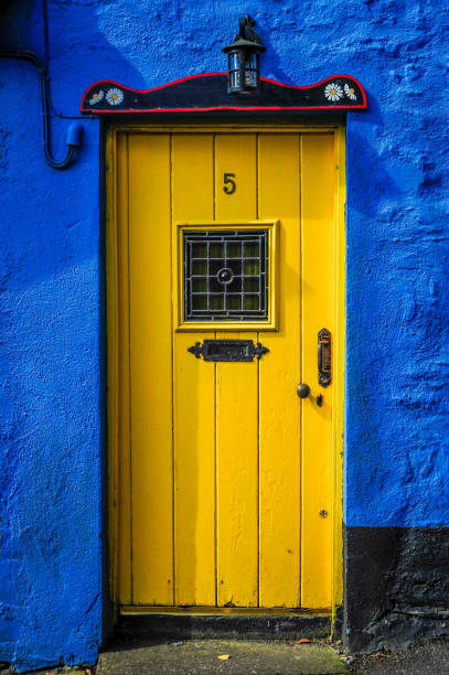 желтая дверь на синей стене - republic of ireland irish culture cottage door стоковые фото и изображения