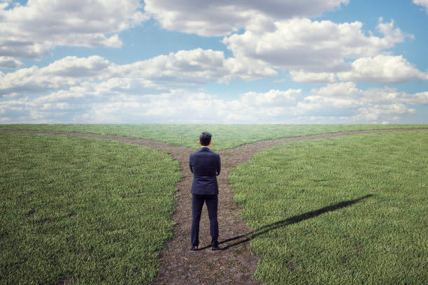 uncertain businessman at crossroad - footpath field nature contemplation imagens e fotografias de stock