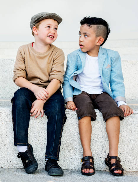 Group of Three Male Caucasian Brothers Standing Together Embraced Over Gray. Vertical Shot