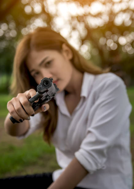 istock Gun in hand beautiful woman 817177386