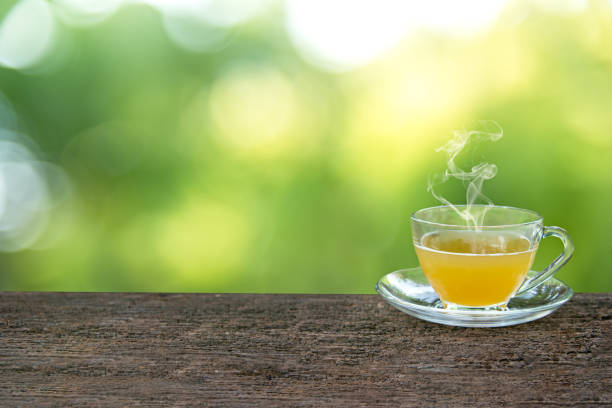 istock Tea cup with and tea leaf sacking on the wooden table and green background 817182538