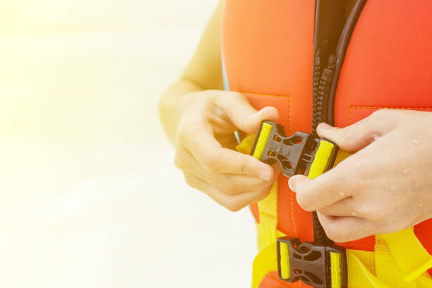 istock child's Hands fasten life jacket. Blurred water in background 817198136