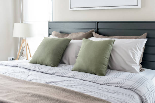 moderne schlafzimmer mit grüne kissen auf dem bett - bedroom mattress contemporary white stock-fotos und bilder
