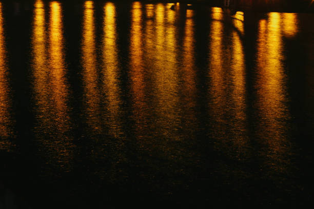 Orange lights reflection off water stock photo