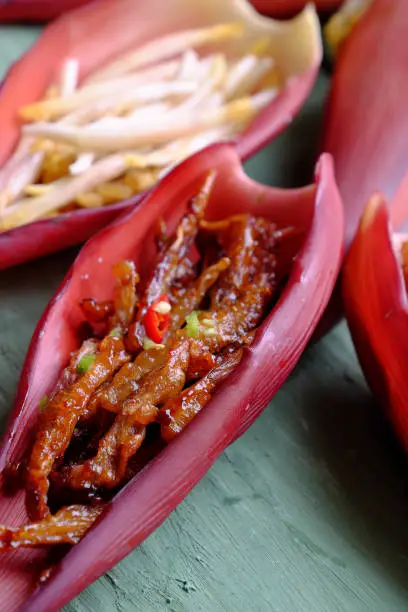 Vegetarian food processing from banana flower, roll young banana fruit with flour then fry and cover with sauce from soy, sugar and chili