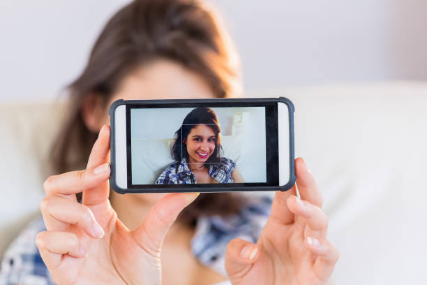 istock Pretty brunette taking a selfie on couch 817209178